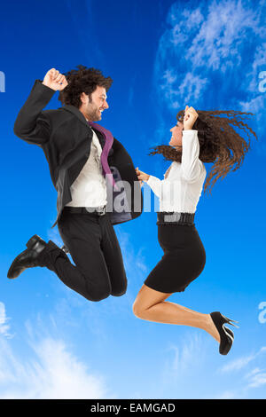 An handsome businessman and a gorgeous businesswoman jumping over a blue sky Stock Photo