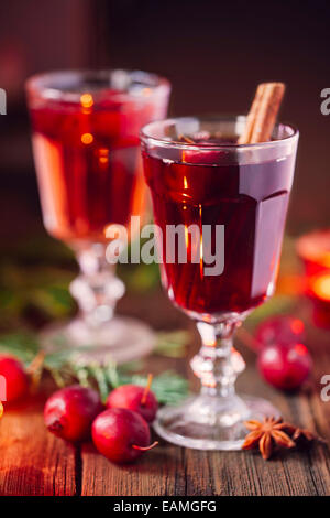 Hot mulled wine with small crab apples, cinnamon stick ans anise closeup Stock Photo