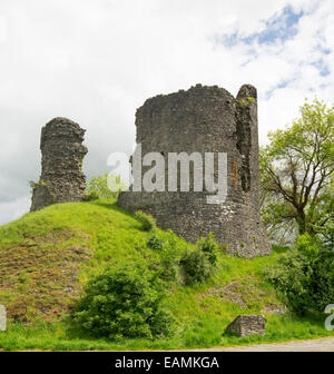 Remains of 12th century castle on grassy hilltop at village of Llandovery, Wales with  ancient stone walls rising into sky Stock Photo
