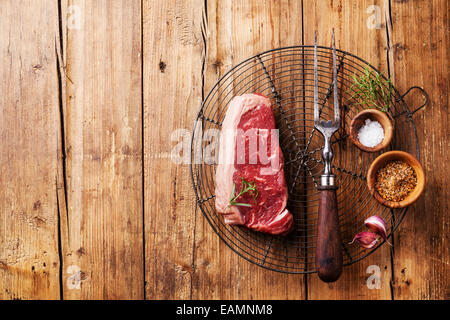 Raw fresh meat of South American premium beef New York steak on Wire Cooling Rack on wooden background Stock Photo