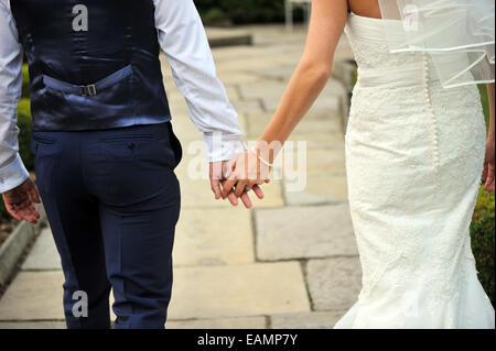 Newly Wed couple walk away holding hands. Stock Photo