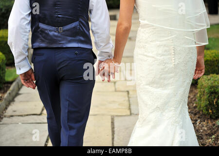 Newly Wed couple walk away holding hands. Stock Photo