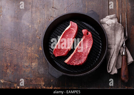 Rare Striploin steak on grill pan on wooden background Stock Photo