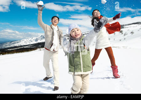 A family of three in the snow snowball fights Stock Photo