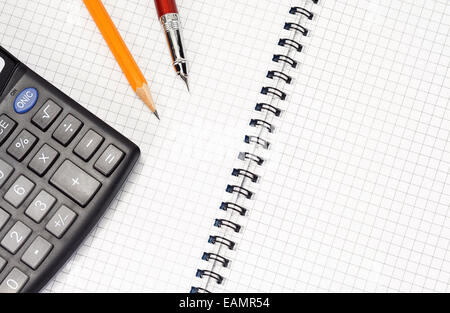 pen and pencil on checked notebook with calculator Stock Photo