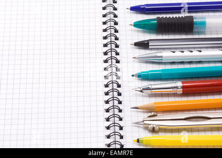 pen, pencil and felt pen on checked notebook Stock Photo