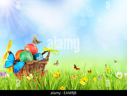 Easter basket full of colored eggs in meadow Stock Photo
