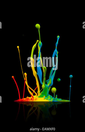 Super macro shot of colored paint splashes 'dancing' on sound waves, isolated on black background Stock Photo