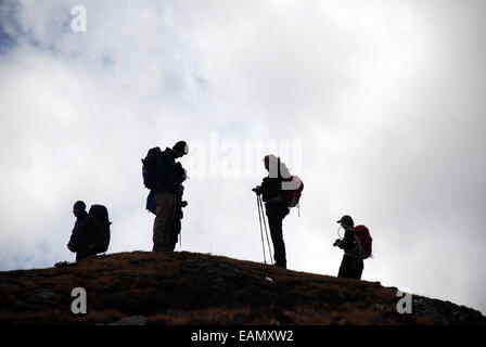 Trekkers stand in the cloud on a high point in the foothills of the Indian Himalayas Stock Photo