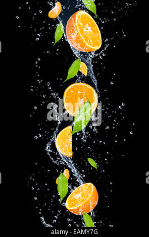 Oranges in water splash, isolated on black background Stock Photo