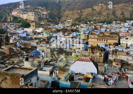 India, Rajasthan, Mewar, Bundi, City Palace in the background, women chatting on the roof of the old town with the blue houses Stock Photo