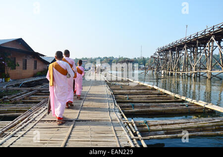 Nun or ascetic women walking on Antique bamboo bridge use instead Saphan Mon wooden bridge at Sangkhlaburi in Kanchanaburi. Stock Photo