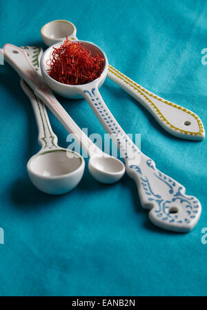 saffron on a decorative measuring spoon on a turquoise background Stock Photo