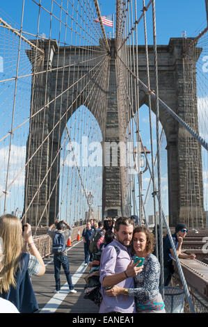 Young couple taking selfie on Brooklyn Bridge Manhattan, New York, USA Stock Photo