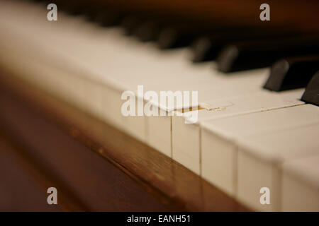 chipped key on a baby grand piano in a music training room Stock Photo