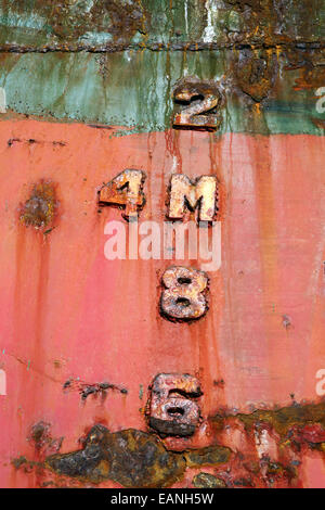 Depth markers on rusty hull of beached ship wreck Stock Photo