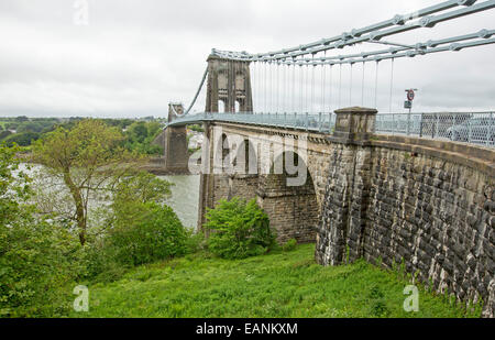 19th century suspension bridge stretching over wide waters of Menai Strait linking Isle of Anglesey to mainland of Wales Stock Photo