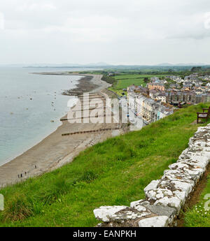 View, from hilltop castle, of historic Welsh town of Criccieth with row of houses by sandy beach of Cardigan Bay & green fields Stock Photo