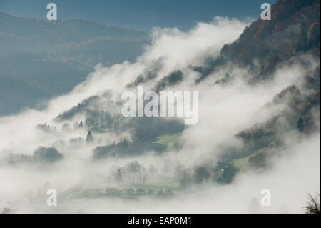 Val D'Arly, Savoie, France. 19th November, 2014. Mist rises as the morning warms up after a cold night. After several days of rainy weather at low altitude and Snow at high altitude the morning breaks with a clear blue sky. Credit:  Graham M. Lawrence/Alamy Live News. Stock Photo