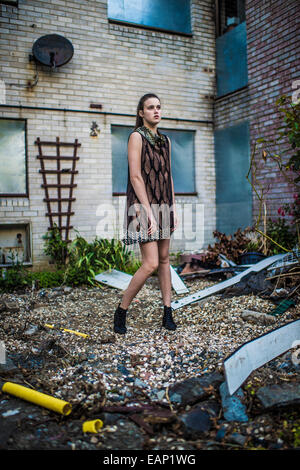 Teenage Girl modeling in the UK: A young 16,17 year old teenage girl model,  wearing a black leather jacket, looking moody, posing in front of a  graffiti covered corrugated iron metal wall