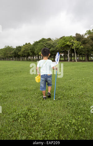 Young boy carrying a butterfly net. Stock Photo
