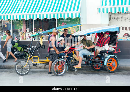 CIENFUEGOS, CUBA - MAY 7, 2014: Cycle rickshaw driver in the shade in Cienfuegos, In Cuba this is a popular means of transport b Stock Photo