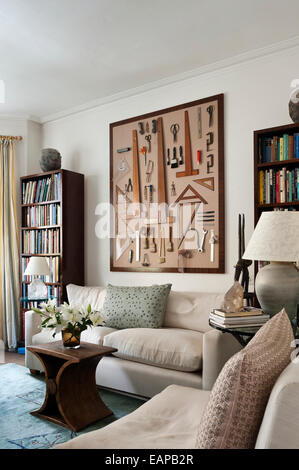 A box frame displaying a variety of tools - paintbrushes, wooden set squares and picture chains - on a living room wall Stock Photo