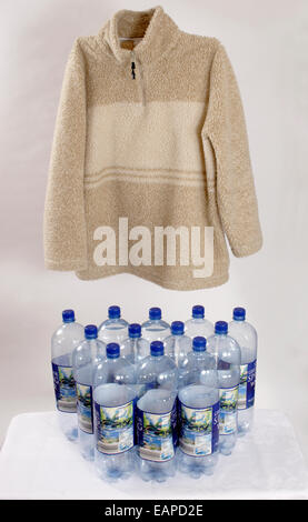 studio shot twelve plastic drinks bottles lying on light coloured fleece jacket Stock Photo
