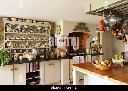 Assorted pottery on dresser in country kitchen with aga and butchers island Stock Photo