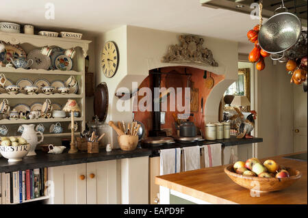 Assorted pottery on dresser in country kitchen with aga and butchers island Stock Photo