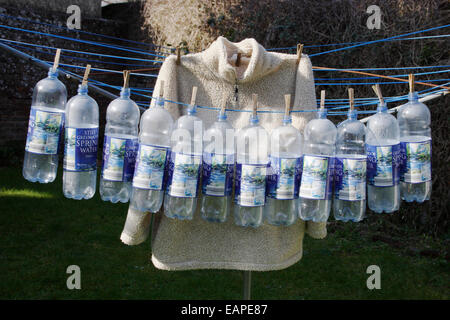 12 plastic bottles & jacket on washing line illustrates hos plastic is recycled into polar fleece Stock Photo