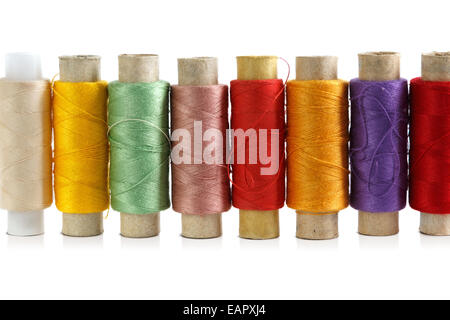 Several spools of brightly colored threads on a white background Stock Photo