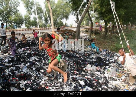 Bangladeshi children swing from a tree in Dhaka Bangladesh is one of the poorest nations on the planet with 40 percent of its 144 million people living on less than 1 dollar a day. Stock Photo