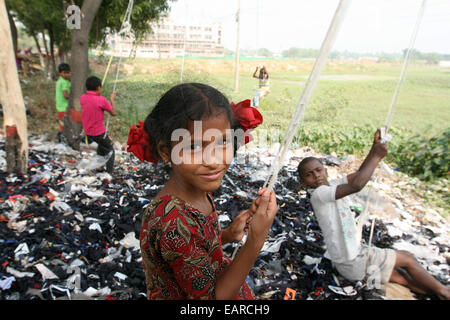 Bangladeshi children swing from a tree in Dhaka Bangladesh is one of the poorest nations on the planet with 40 percent of its 144 million people living on less than 1 dollar a day. Stock Photo