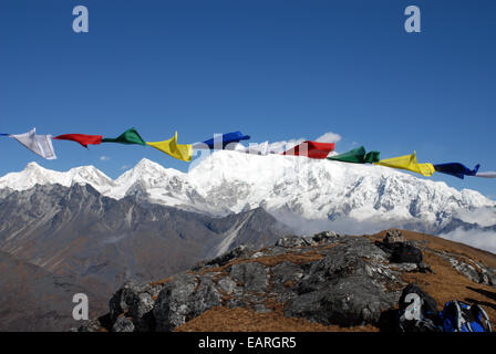Kangchenjunga is framed by Buddhist prayer flags in this view taken from a high point on the Singalila ridge in India Stock Photo
