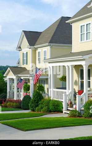 American Flags hang from the front porches in a neighborhood of upscale, Victorian homes in celebration of the upcoming holiday. Stock Photo