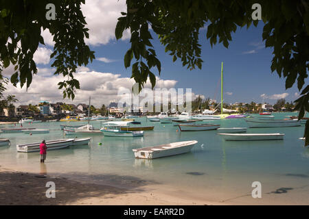 Mauritius, Grand Baie, public beach, Hindu man praying in shallows amongst leisure boats Stock Photo
