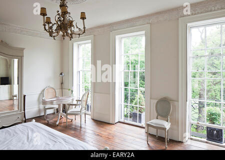 White bedroom with full length windows in the Reading Rooms, Margate, England, UK. Stock Photo