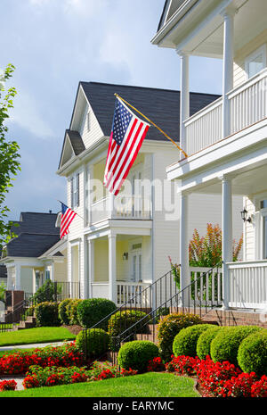 American Flags hang from the front porches in a neighborhood of upscale, Victorian homes in celebration of the upcoming holiday. Stock Photo