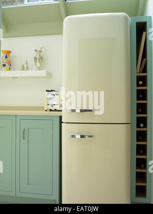 Fridge next to blue units in contemporary kitchen Stock Photo