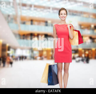 smiling elegant woman in dress with shopping bags Stock Photo