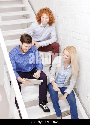 team with tablet pc computer sitting on staircase Stock Photo