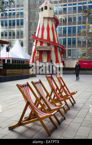 Old traditional wooden Helter-Skelter, a Childrens's fairground spiral slide, at Manchester UK, 20th November, 2014. Red & White Seaside Theme in the city cente an Extension of the Christmas market. Stock Photo