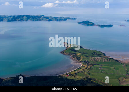 A peninsular dotted with lush farmland fingers into a turquoise bay. Stock Photo