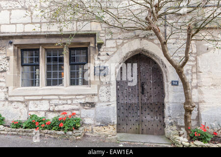 A 14th century cottage in Bisley Street with Donkey door in the Cotswold village of Painswick, Gloucestershire, England, UK Stock Photo