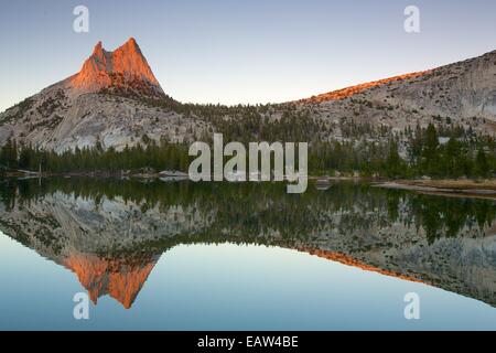 Sunset with Cathedral Peak reflecting in Upper Cathedral Lake in Yosemite National Park Stock Photo