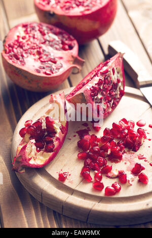 red pomegranate on wooden table Stock Photo
