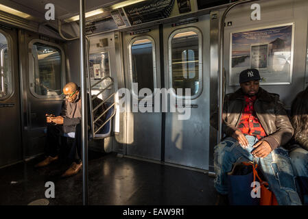 New York, NY 20 November 2014 - Subway riders on the N train to Brooklyn. Stock Photo