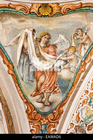 SEVILLE, SPAIN - OCTOBER 28, 2014: The baroque fresco of angel with the vestment in church Hospital de los Venerables Sacerdotes Stock Photo