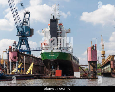 A vessel is lifted up for maintenance in a dry dock at Hamburg harbor Stock Photo